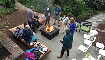 Participants gather around a backyard fire pit in a 2018 Fireside Circle